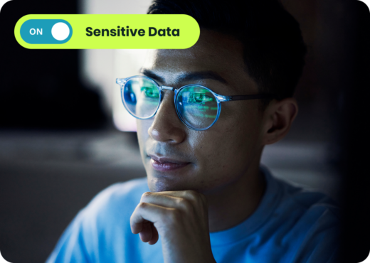 Man with glasses lit by screen, blue toggle button at ON, green toggle bar saying Sensitive Data